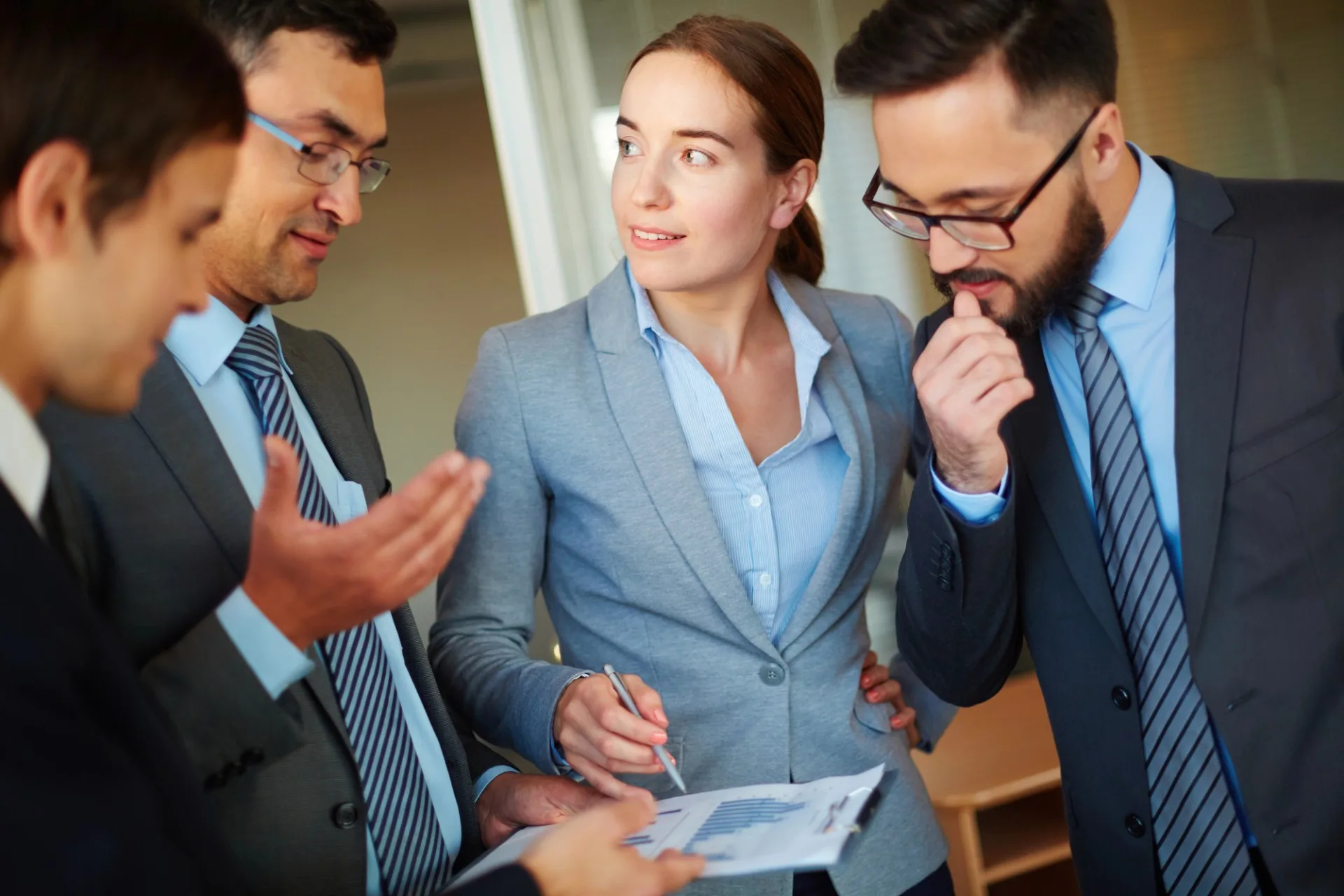 photo of a diverse group of business colleagues review financial statements and reports prepared by their Edmonton bookkeeper at ProFit Bookkeeping